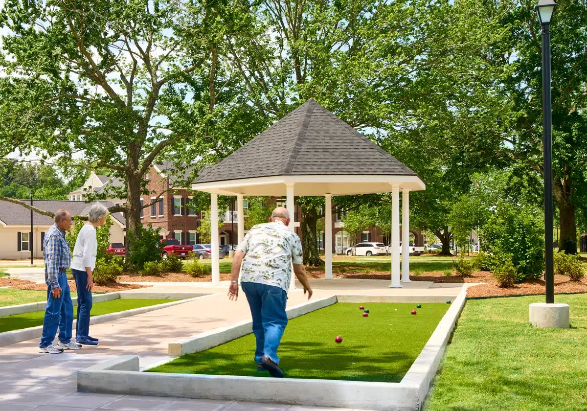 Man playing bocce ball in a park nearby a gazebo in the glen in Shreveport, LA