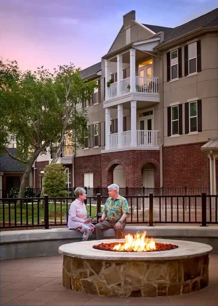 Outdoor fire place with two residents seated near it