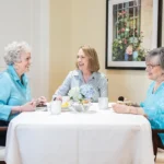 Three women enjoying coffee together at a table